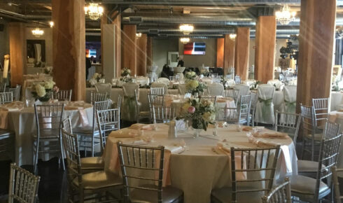 Riverwalk venue set for a wedding reception with round tables and low centerpieces.