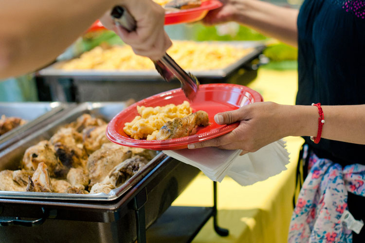 Filling plates with chicken and mac and cheese.