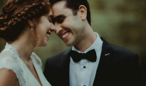 Bride and groom smiling while pressing their foreheads together at Boerner Botanical Gardens
