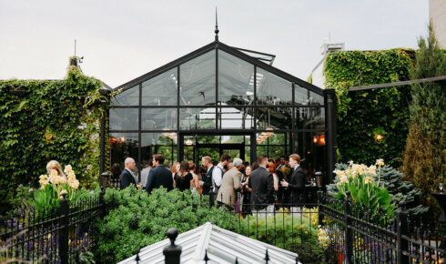 Exterior of The Atrium, clear glass and metal frame, guests surround.