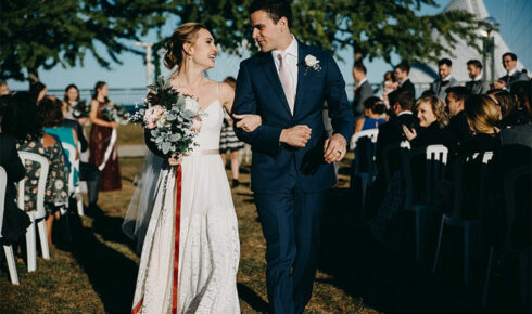 Bride and groom walking back up the isle after their ceremony.