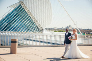 Bride and groom with The Milwaukee Art Museum in the background.