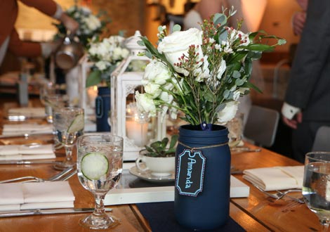 Table setting with a black mason jar filled with flowers and a name tag for Amanda.