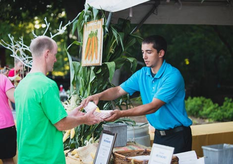 A Zilli staff member serving corn on the cob.