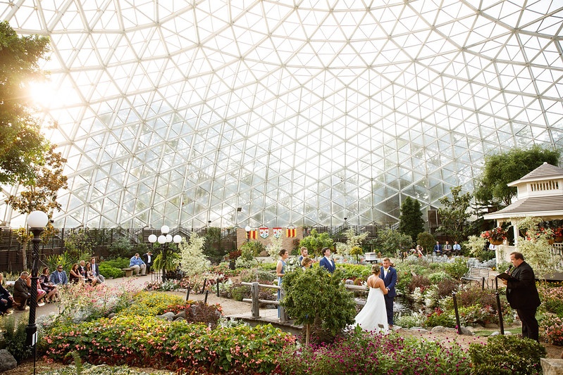 Bride and groom holding hands and looking into each others eyes saying their vows inside The Domes.