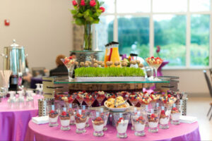 Mini parfait and fruit cups set up on a table for guests.