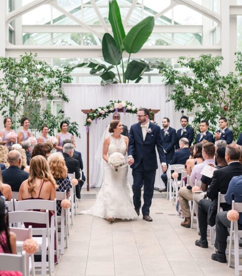 Bride and groom holding hands while walking back up the isle after their ceremony.