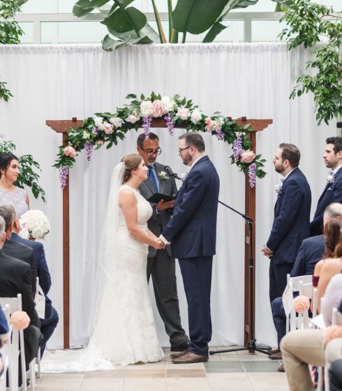 Bride and groom holding hands at the alter.