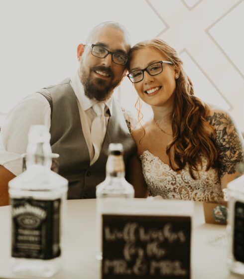 Bride and groom sitting and smiling at the camera.