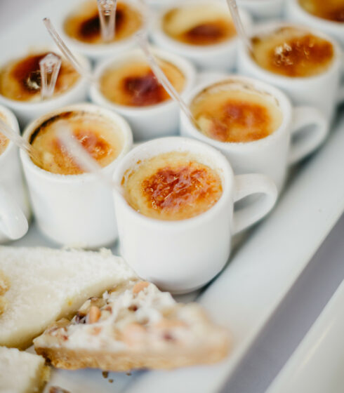 Small mugs of crème brulee on a tray.