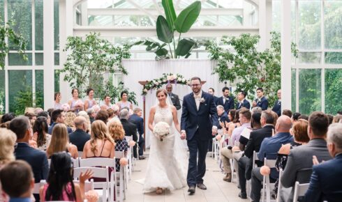 A bride and groom walking back up the isle after getting married.