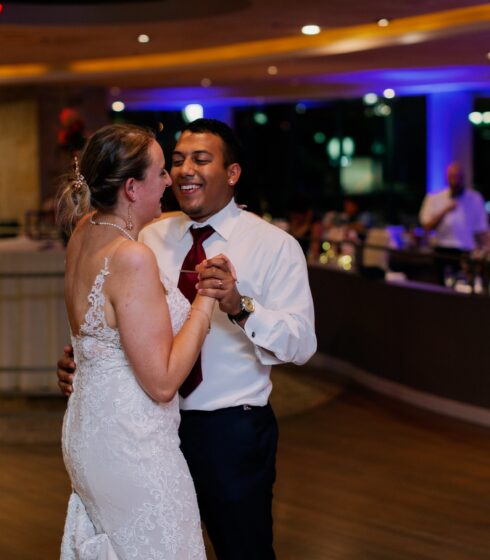 Bride and groom smiling while dancing to a slow song.