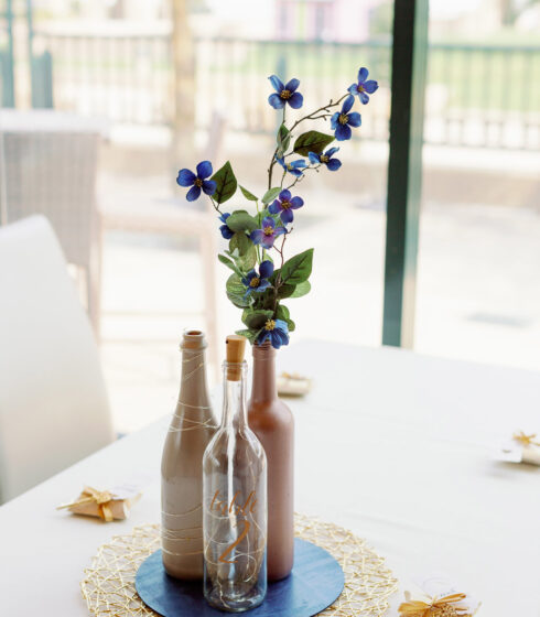 Three bottles used a centerpiece with flowers