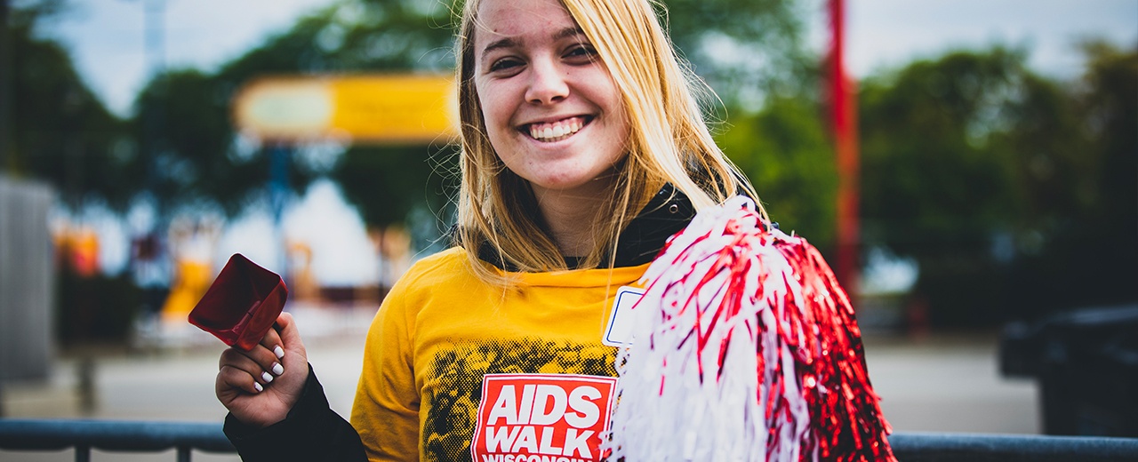 Teen girl smiling at the camera wearing aids walk wisconsin shirt