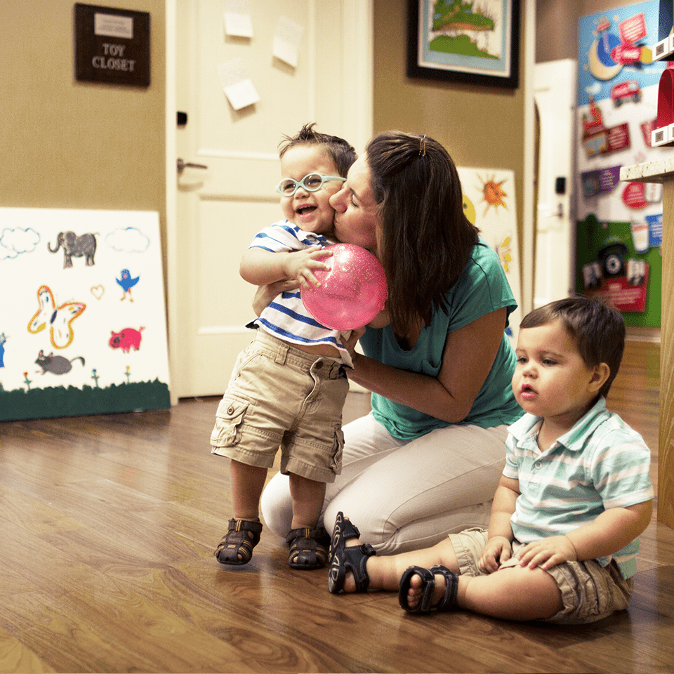 Mother and two toddlers sitting on the ground