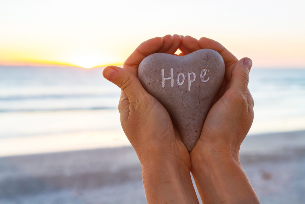 Hands holding rock labeled hope