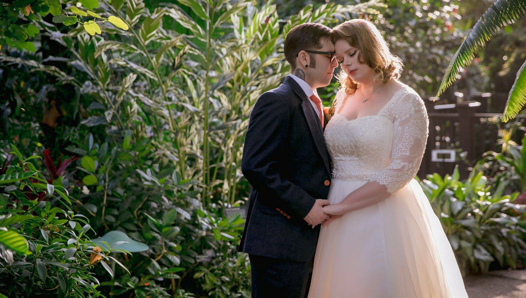 wedding couple in front of green plant background
