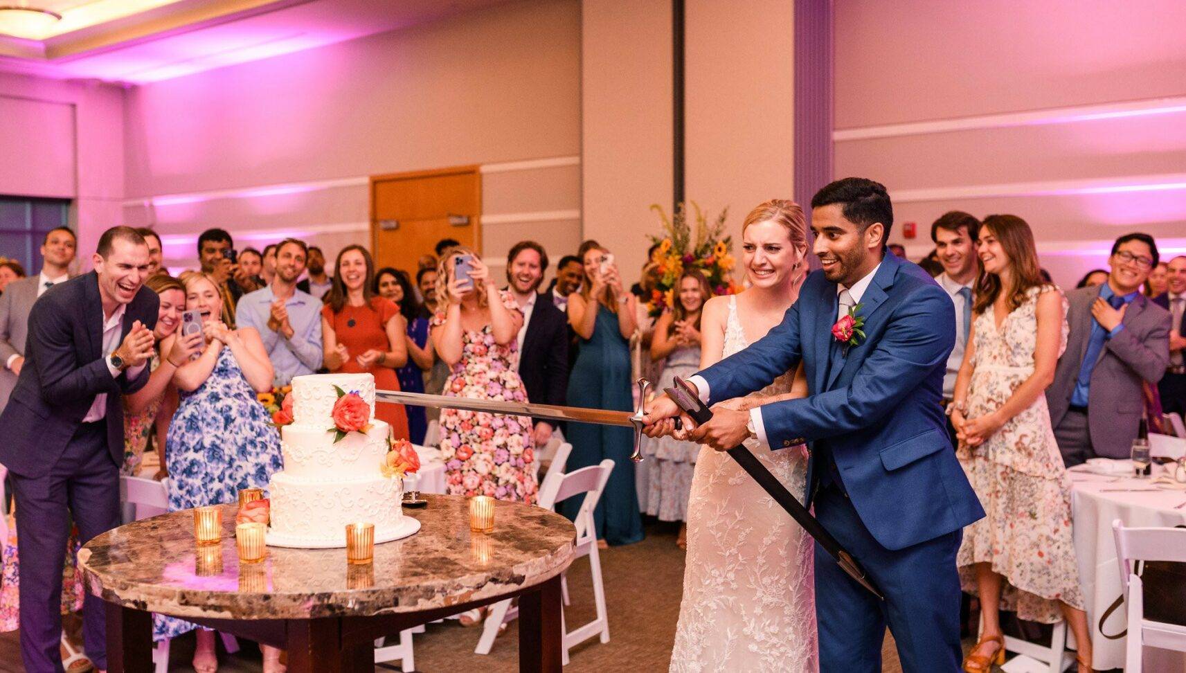 wedding couple cutting the cake with a sword