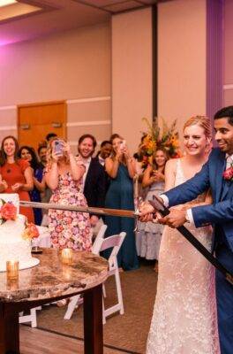 wedding couple cutting the cake with a sword