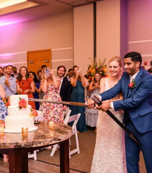 wedding couple cutting the cake with a sword
