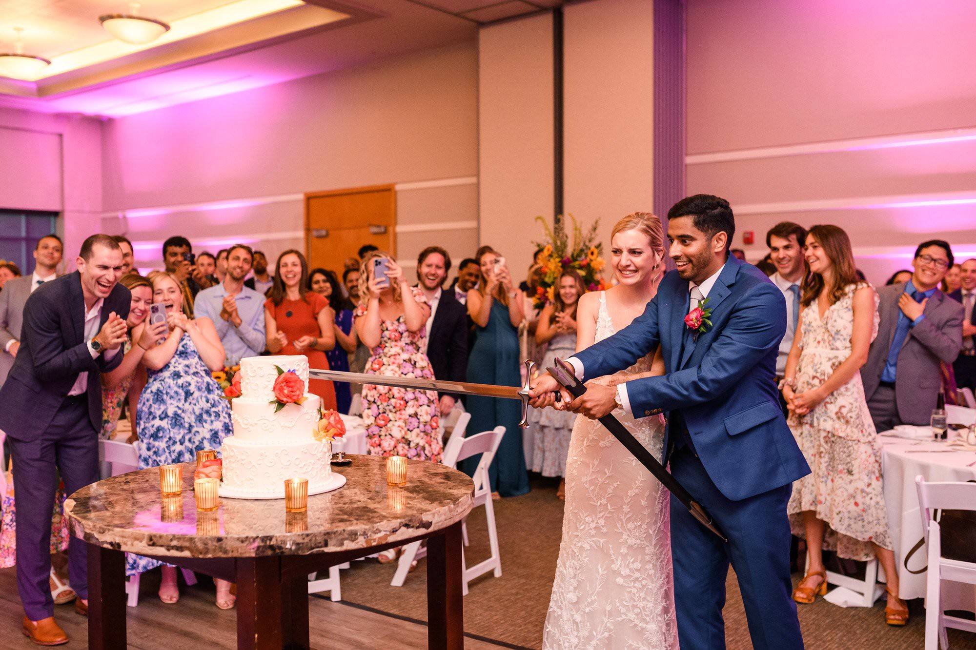 wedding couple cutting the cake with a sword