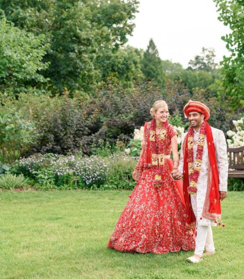 couple walking outside dressed in Indian wedding attire