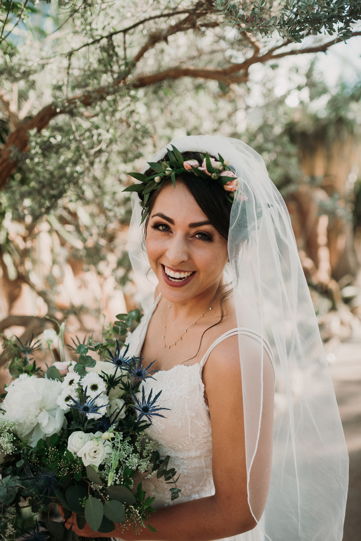 Bride smiling under the trees at Mitchell Park Domes