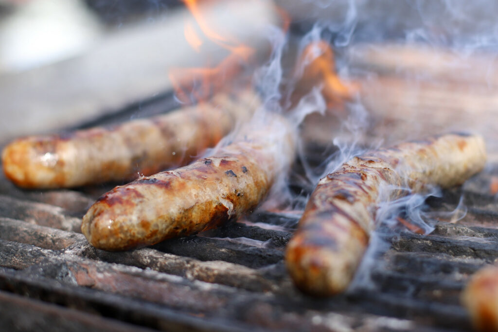 brats cooking on the grill