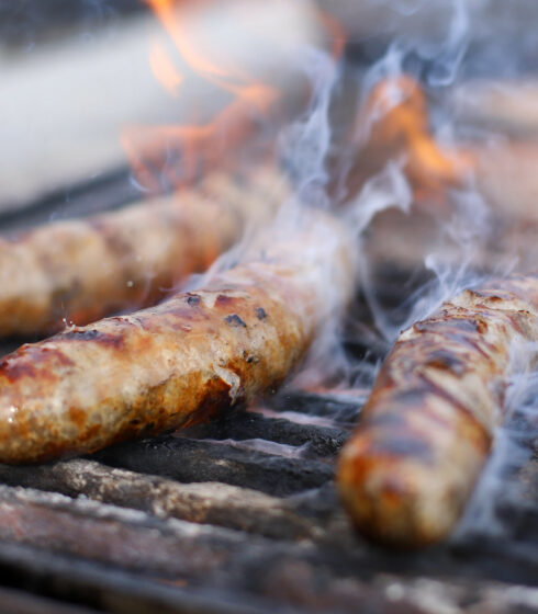 brats cooking on the grill