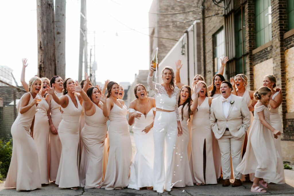 wedding party popping champagne bottle
