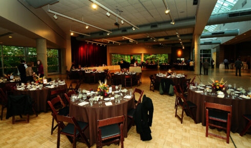 Dark brown tables with fall floral centerpieces.