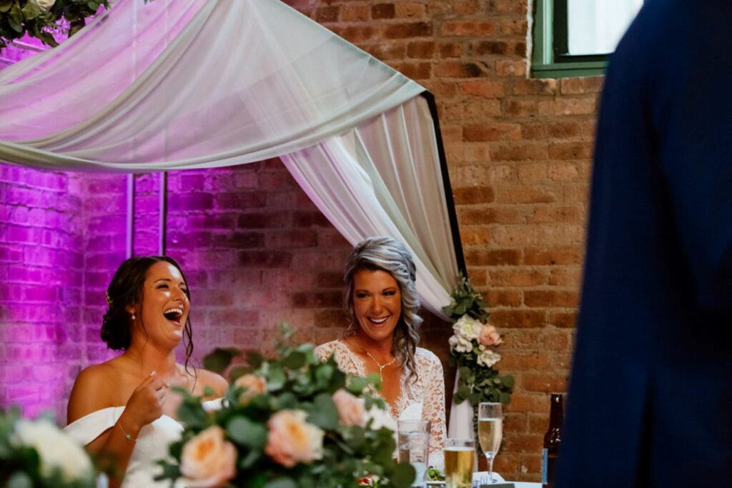 happy wedding couple listening to speeches