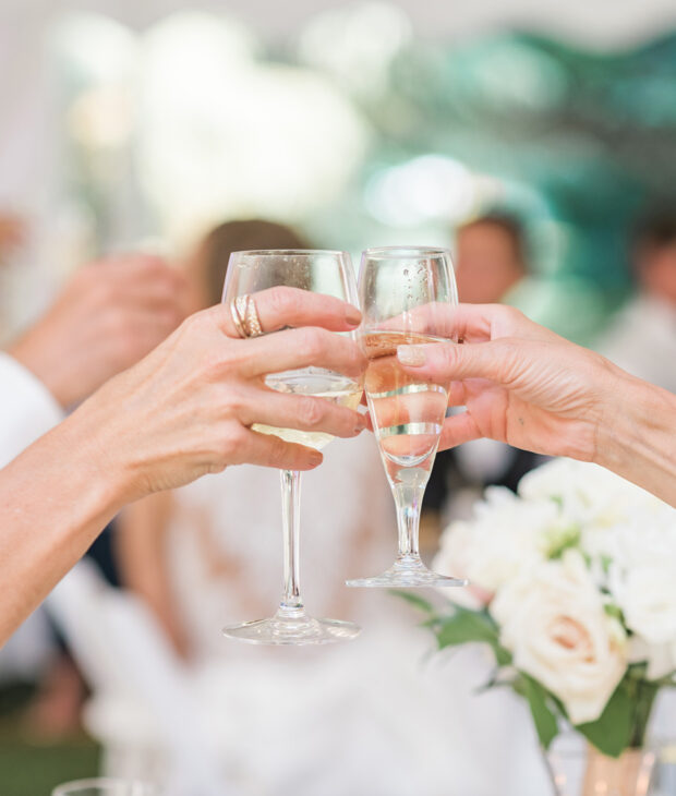 two people clinking champagne glasses together in cheers