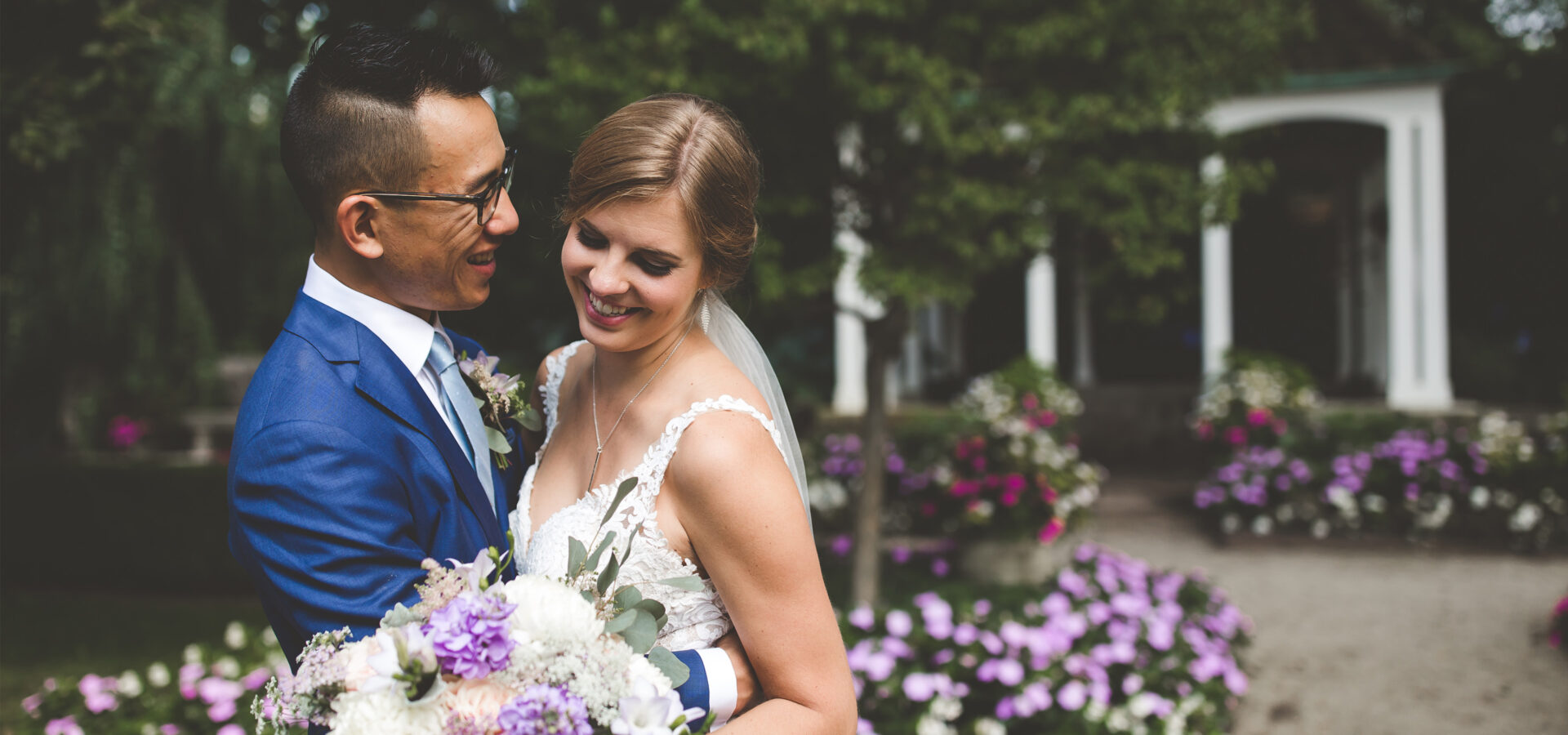 a bride and groom holding each other in a garden full of flower