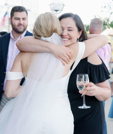 Bride hugging friend at wedding