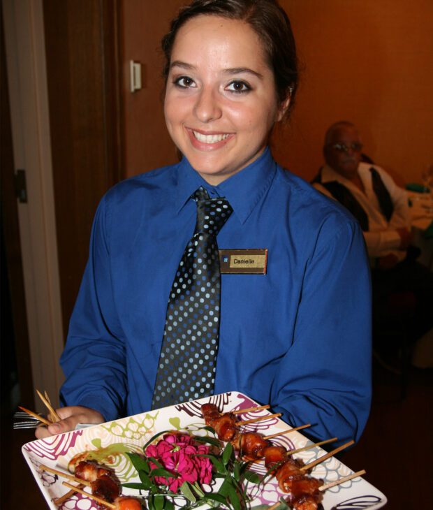 Server holding kebabs