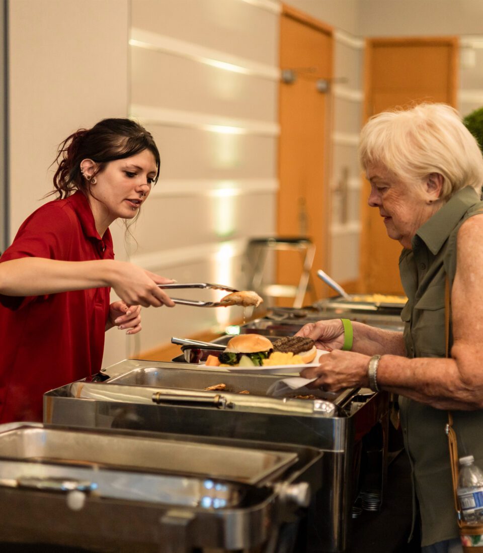 Woman serving burgers at buffet