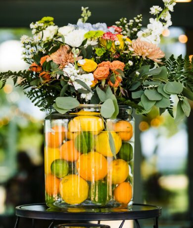 Floral display in vase filled with oranges, lemons and limes